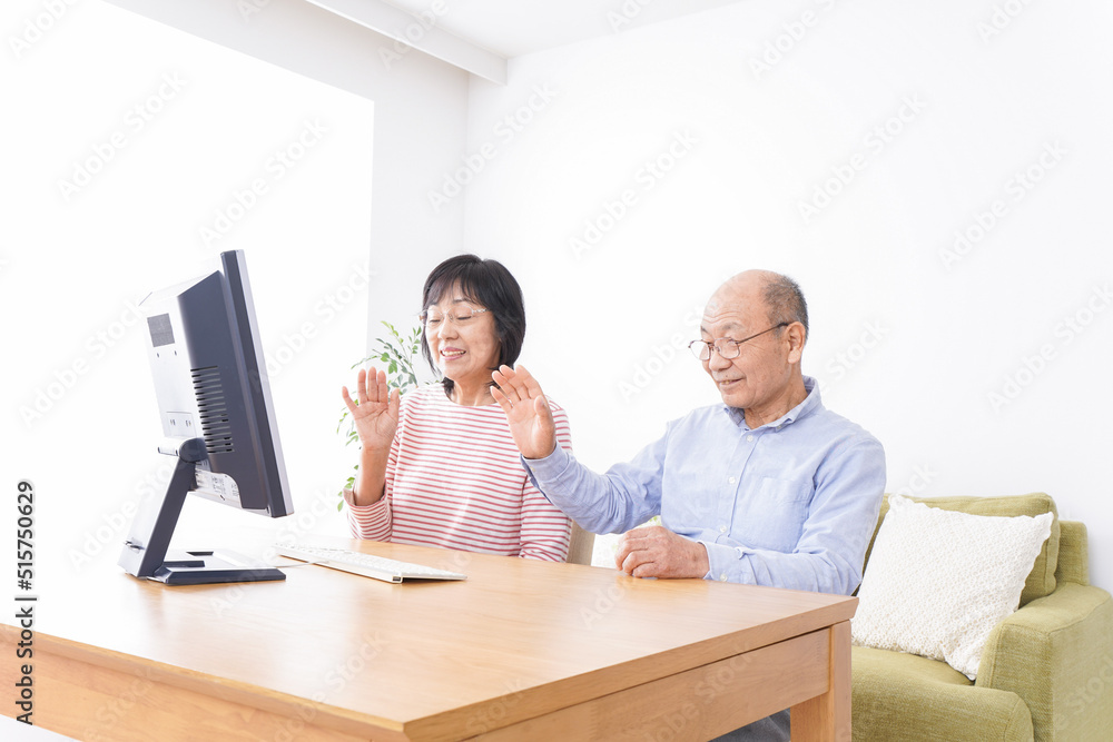 パソコンでテレビ電話をする高齢の夫婦 パソコンでテレビ電話をする高齢の夫婦