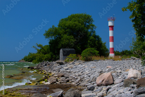 striped lighthouse on rocky beach