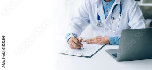 Online medical consultation  doctor working on laptop computer in clinic office, healthcare, medical service, consultation or education, healthy lifestyle concept