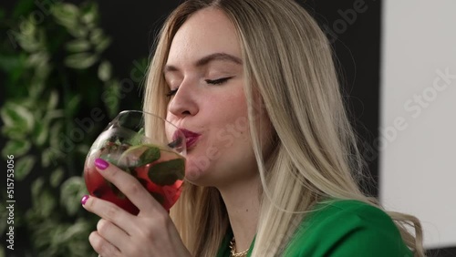 Blonde with pleasure drinking a delicious cocktail photo