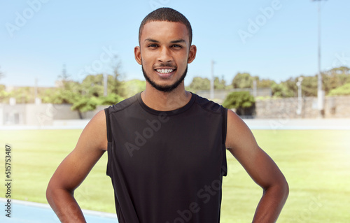 Portrait of a fit active young athlete standing alone before going for a run on a track field. Latino male looking confident and smiling outside getting ready to do his daily routine exercise outside