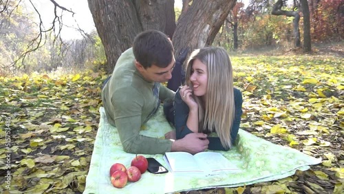 Slow Motion Young couple reading book in autumn park. Happy family.