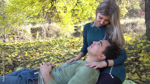 Romantic young couple enjoys a wonderful day lying on the blanket in autumn.