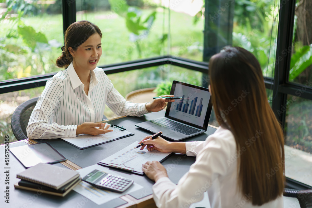 Coworker business concept, Businesswoman reading chart financial to discussing new project together Coworker business concept, Businesswoman reading chart financial to discussing new project together