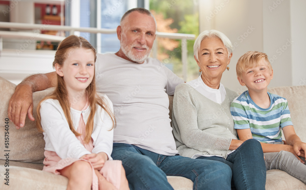 Two siblings relaxing with their grandparents together at home on a couch. Sister and brother visiting grandparents. A happy caucasian mature couple bonding with their adopted kids in the living room Two siblings relaxing with their grandparents together at home on a couch. Sister and brother visiting grandparents. A happy caucasian mature couple bonding with their adopted kids in the living room