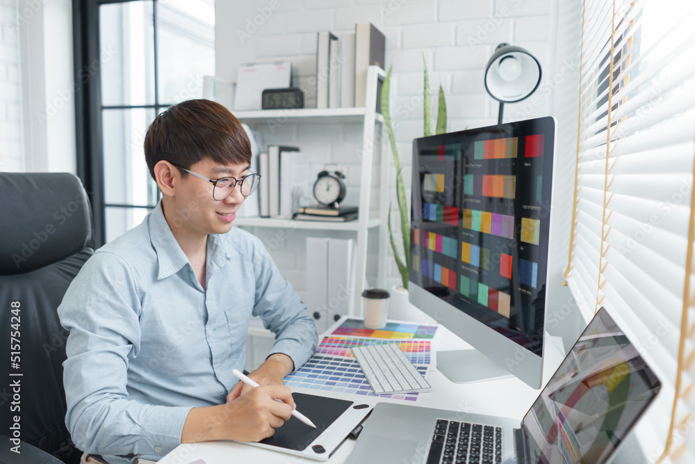 Creativity concept, Male graphic designer using tablet and looking color swatch samples on screen Creativity concept, Male graphic designer using tablet and looking color swatch samples on screen