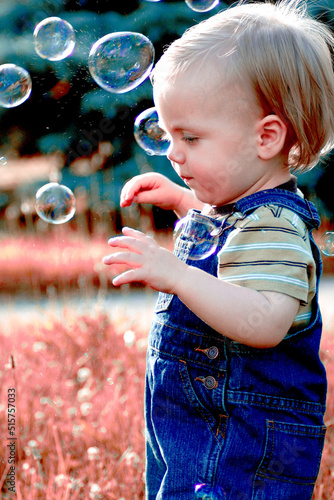 Little boy playing with bubbles in the fall