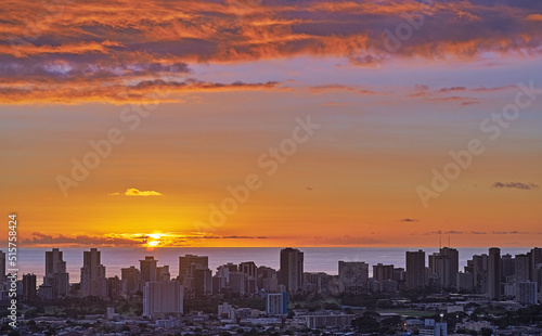 A fiery red sunset cityscape and beach with sunset sky in evening. Birds eye view of a city and colorful sky with clouds at night background with summer sunrise and wonderful view of an urban town