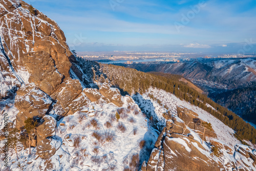 Aerial top view city Krasnoyarsk Russia taiga forest and rocks of stolby sanctuary, winter sunset photo