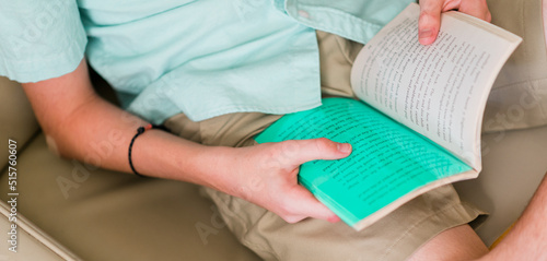 Dyslexic child reading with dyslexia color overlay to make a book easy to read. Kid relaxing reading a book. photo