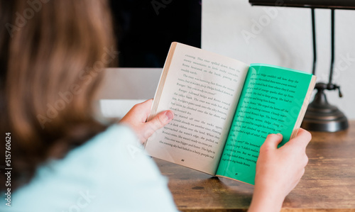 Dyslexic child reading with dyslexia color overlay to make a book easy to read. 