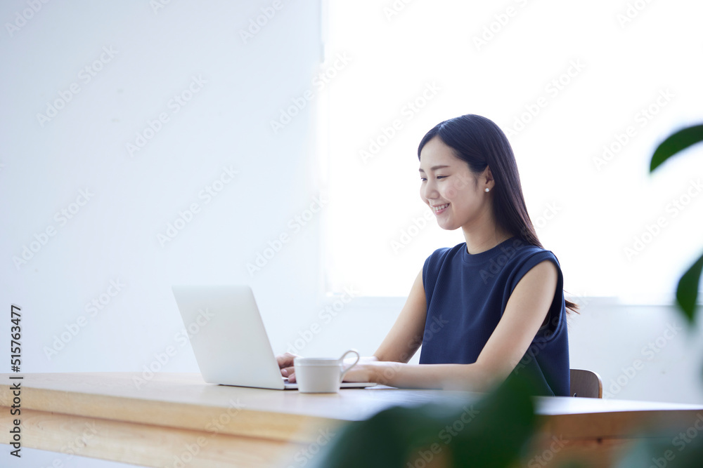 リビングでリモートワークを行う若い日本人女性 リビングでリモートワークを行う若い日本人女性