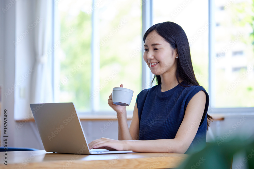 リビングでリモートワークを行う若い日本人女性 リビングでリモートワークを行う若い日本人女性