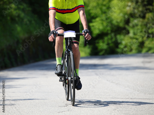 Fototapeta Naklejka Na Ścianę i Meble -  cyclist with racing bike and sportswear while pedaling fast through the paved roads during a workout