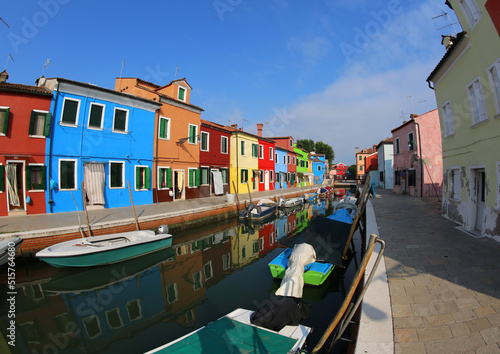 Burano Island near Venice with colorful houses and more boats in the navigable canal without people