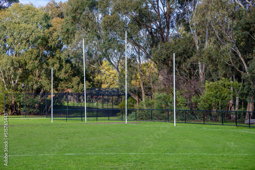 Australian Football League goal posts in a suburban sports oval with cricket practice nets in the background photo
