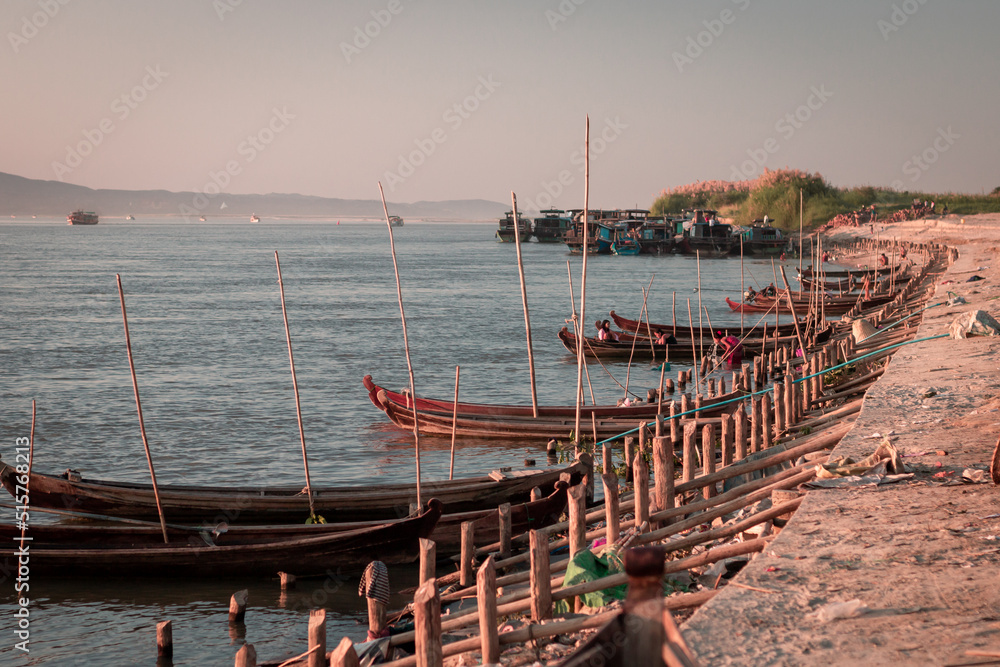 Mandalay, Myanmar - November 2019 : fishermen boats on the banks of the Irrawaddy river in Mandalay at sunset.