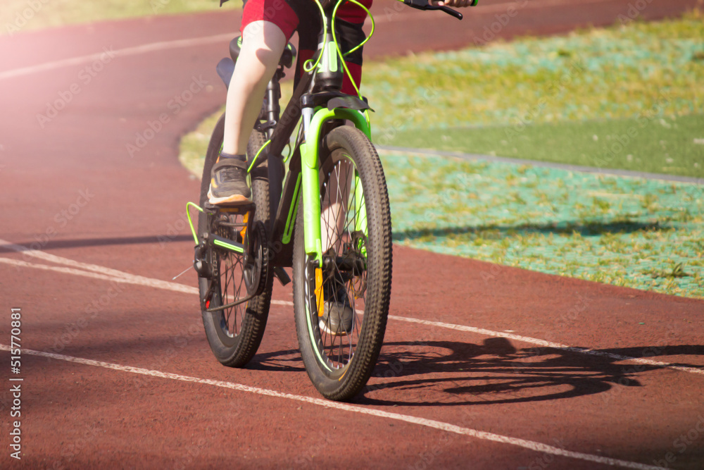 Fototapeta premium A boy on a bicycle rides around the stadium, the wheel is very close, cycling