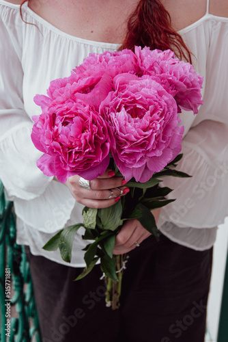 Woman holding a beautiful bouquet of pink peonies for wedding celebration