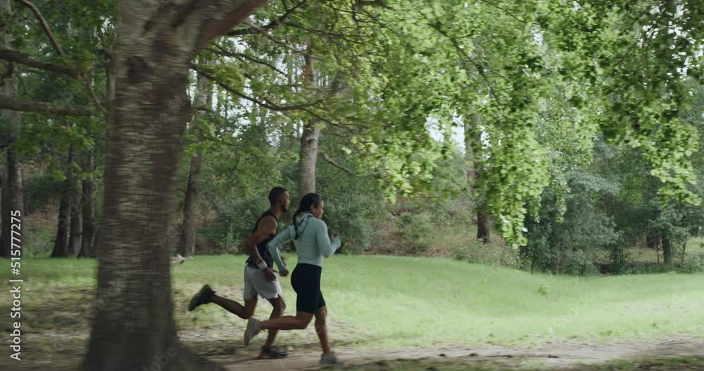 Active people jogging outdoors in a green forest on summer day. Athletic man and woman running together in nature as part of fitness and cardio training. Runners doing their morning workout routine Active people jogging outdoors in a green forest on summer day. Athletic man and woman running together in nature as part of fitness and cardio training. Runners doing their morning workout routine