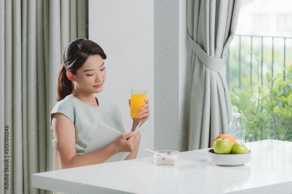 Woman is reading a book and having breakfast Woman is reading a book and having breakfast