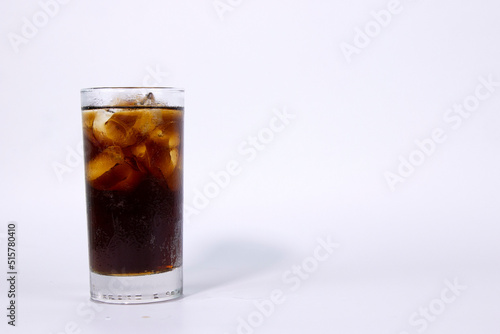 A isolated glass of black cola with ice is filled on white background used in ads