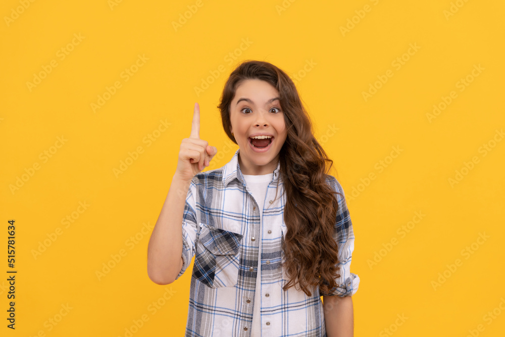 inspired teen child in checkered shirt with long curly hair on yellow background inspired teen child in checkered shirt with long curly hair on yellow background