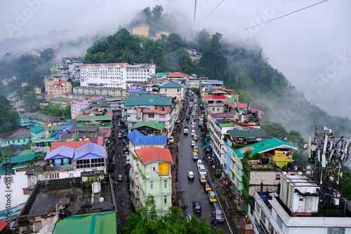 Gangtok, Sikkim, Tourists enjoy a ropeway cable car ride over Gangtok city. Amazing aerial cityscape of Sikkim. covered in mist or fog. North east India tourism, Amazing aerial cityscape of Sikkim. photo