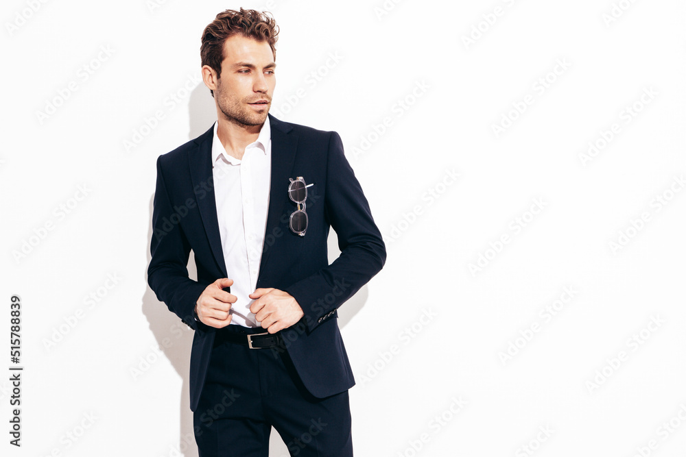 Portrait of handsome confident stylish hipster lambersexual model. Sexy modern man dressed in black elegant suit. Fashion male posing in studio. Isolated. Full length Portrait of handsome confident stylish hipster lambersexual model. Sexy modern man dressed in black elegant suit. Fashion male posing in studio. Isolated. Full length