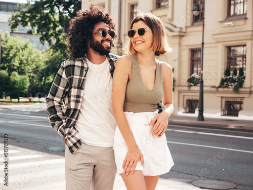 Smiling beautiful woman and her handsome boyfriend. Sexy cheerful multiracial family having tender moments in the street at sunset. Multiethnic models hugging. Embracing each other.Love concept