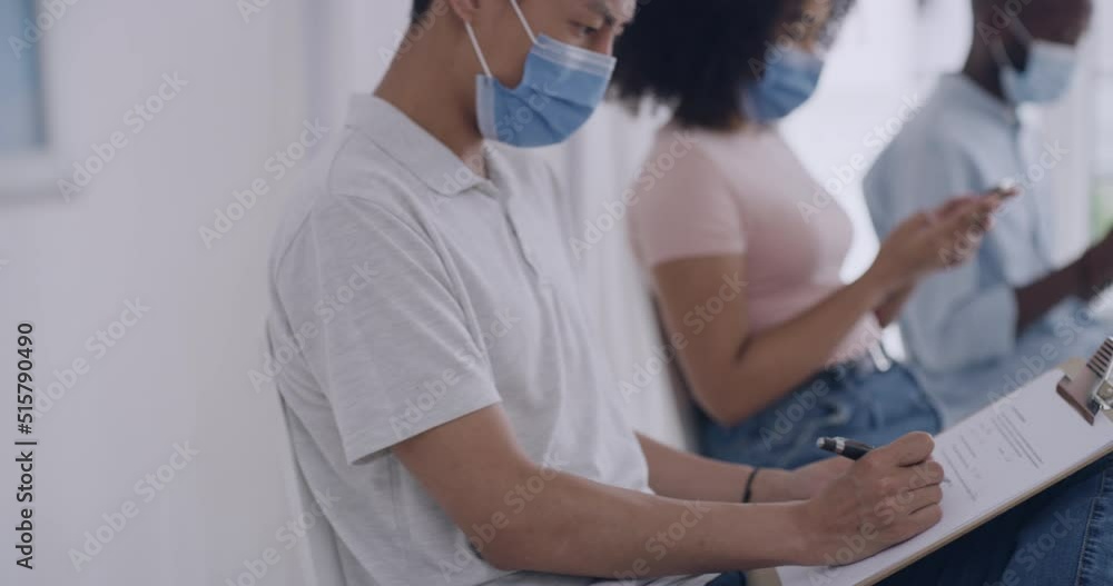 People waiting in line for covid vaccines in a hospital or clinic. Patient filling in and signing an informed medical consent form while sitting in a queue for a booster shot for immunity to diseases People waiting in line for covid vaccines in a hospital or clinic. Patient filling in and signing an informed medical consent form while sitting in a queue for a booster shot for immunity to diseases