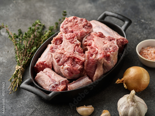 Quadro su tela Raw oxtail cut on a tray with spices, onion and garlic to cook it on the gray table
