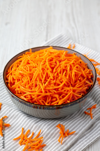 Raw Orange Carrot Shreds in a Bowl, low angle view.