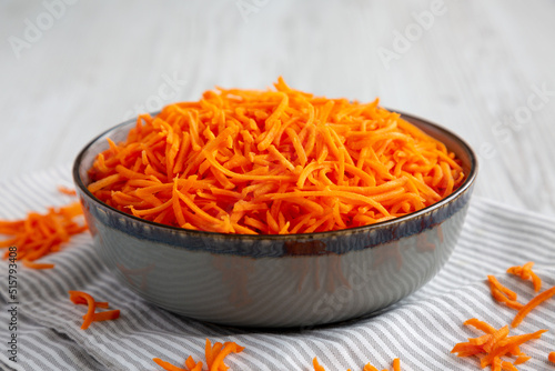 Raw Orange Carrot Shreds in a Bowl, low angle view. Close-up.