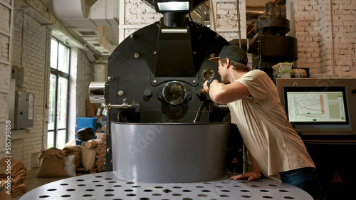 Barista or worker operate coffee roasting machine