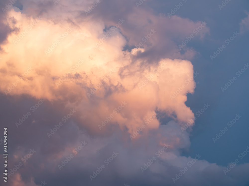 Cumulus clouds shines orange at the horizon during the thunderstorm. Weather, clouds, temperature and meteorology.