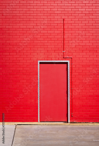 red brick wall with doorway and red door photo