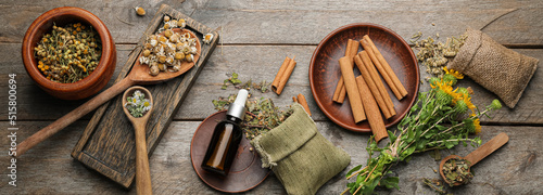Obraz na plátne Bottle of essential oil with herbs and spices on wooden background