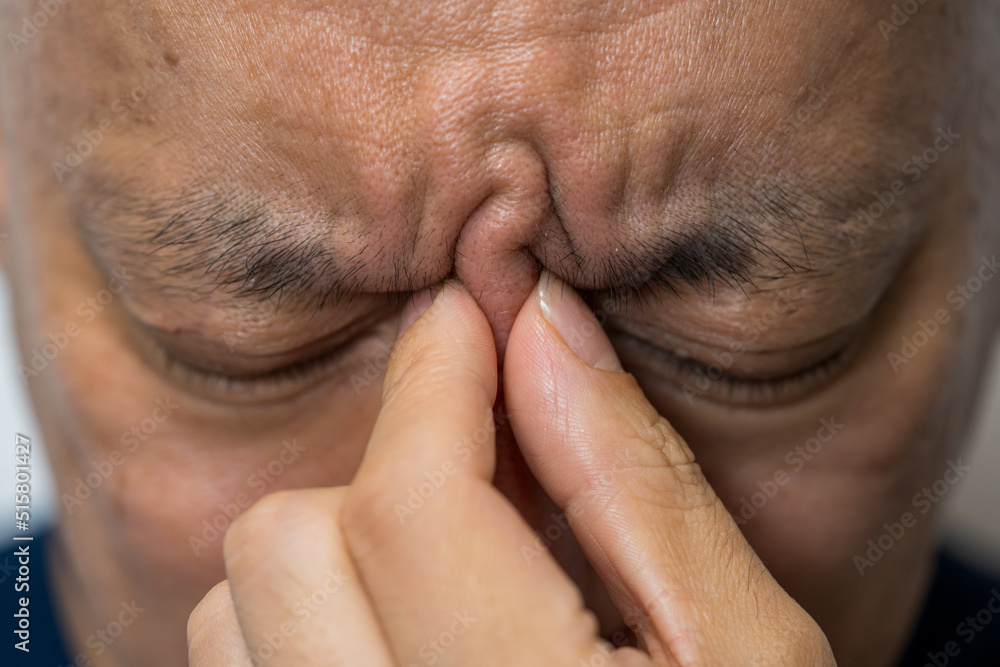 目頭を押さえる男性 目頭を押さえる男性