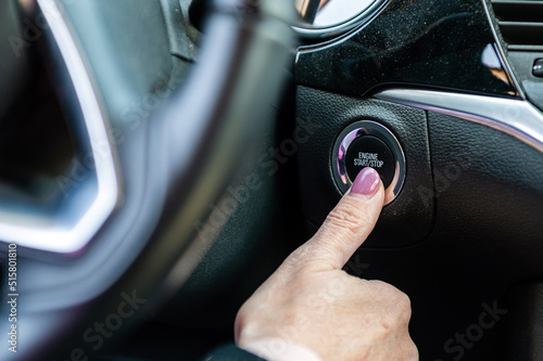 Woman hand pushing on car engine start-stop button. Modern car interior, closeup © ako-photography