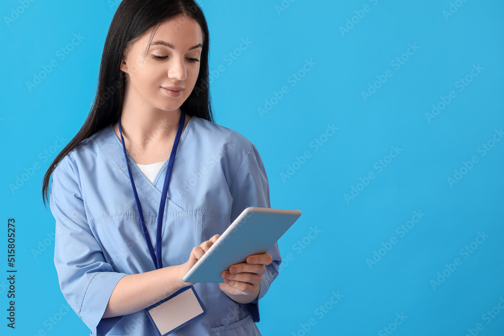 Female medical assistant using tablet computer on blue background Female medical assistant using tablet computer on blue background
