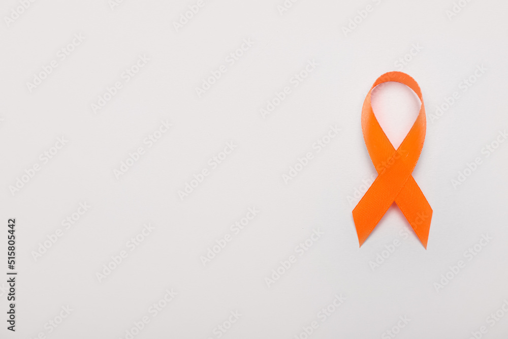 Orange awareness ribbon on grey background. Kidney cancer concept Orange awareness ribbon on grey background. Kidney cancer concept
