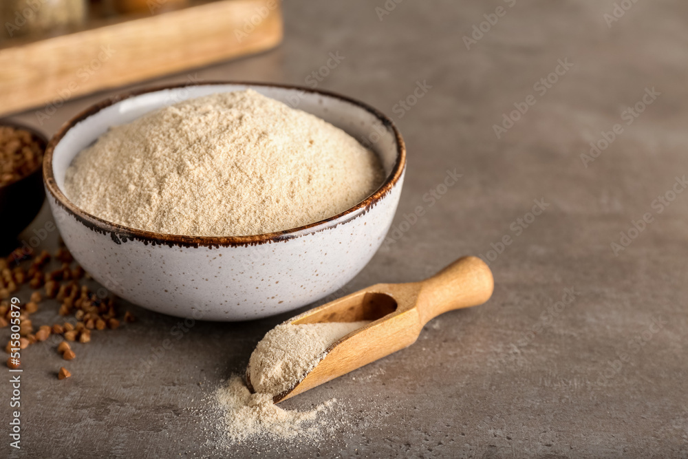 Bowl of flour, scoop and buckwheat grains on grunge background Bowl of flour, scoop and buckwheat grains on grunge background