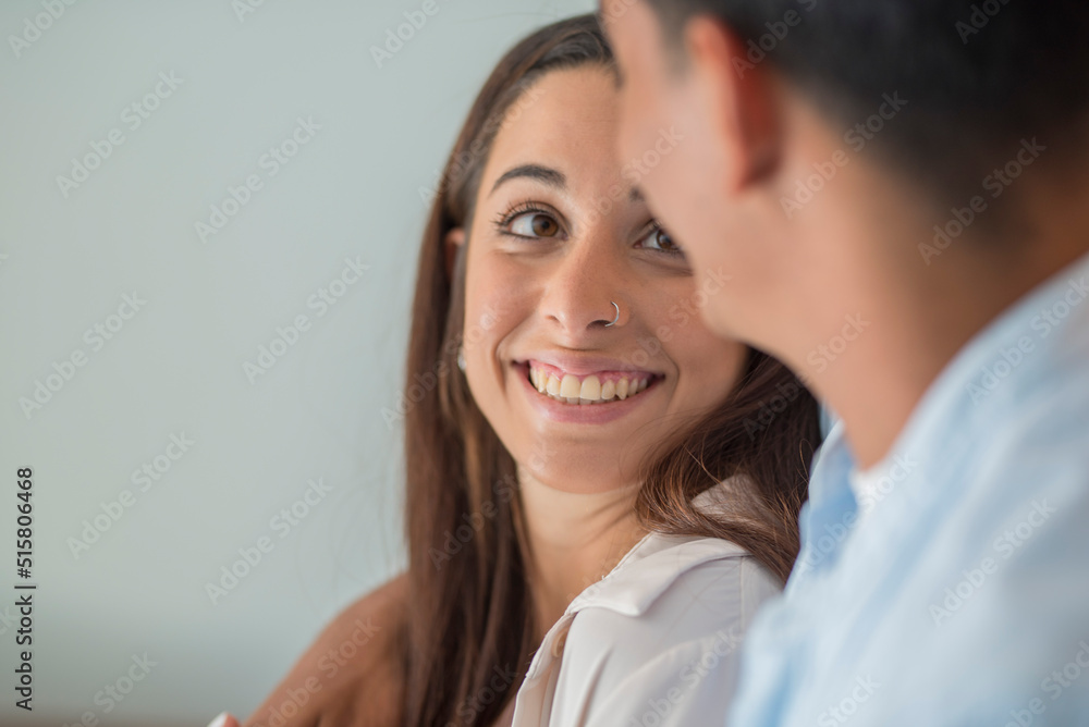 Side portrait view of happy woman smiling and looking her boyfriend. Young couple in love and relationship. Friendship between man and woman. White background. Indoor home leisure people Side portrait view of happy woman smiling and looking her boyfriend. Young couple in love and relationship. Friendship between man and woman. White background. Indoor home leisure people