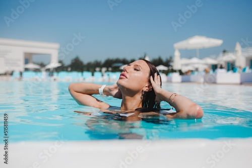 beautiful girl swimming in the pool, summer vacation by the pool, girl drinking cocktail by the pool © Natalia Rzhevskaia