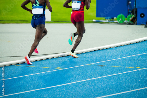 Endurance running, athletics and Track and Field. The legs of two African female runners on the track. Illustrative photo for marathon and running in Kenya
