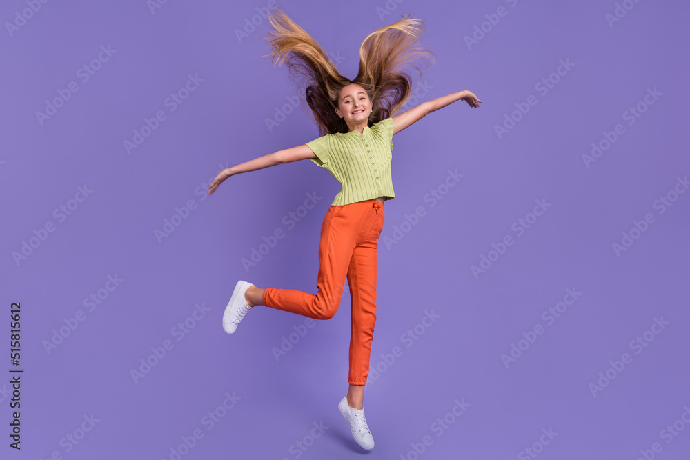 Full length portrait of overjoyed girl jumping throw hair rejoice good mood isolated on purple color background