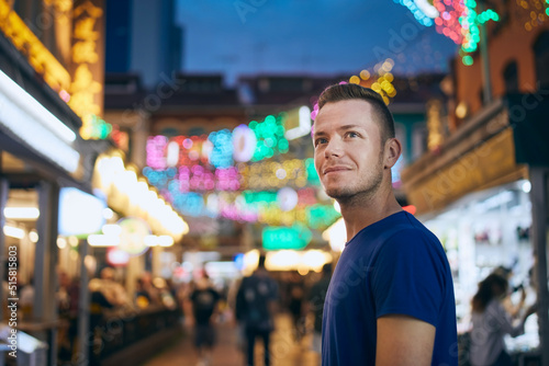 Photography Portrait of man on evening illuminated street market