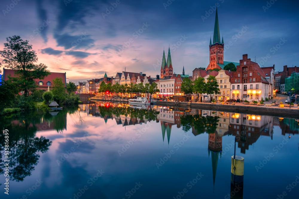 Lubeck, Germany. Cityscape image of riverside Lubeck  with reflection of the city in Trave River at sunset.