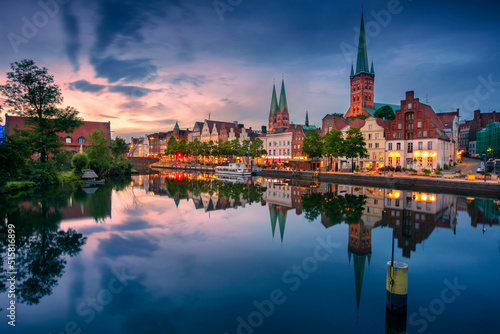 Lubeck, Germany. Cityscape image of riverside Lubeck with reflection of the city in Trave River at sunset.